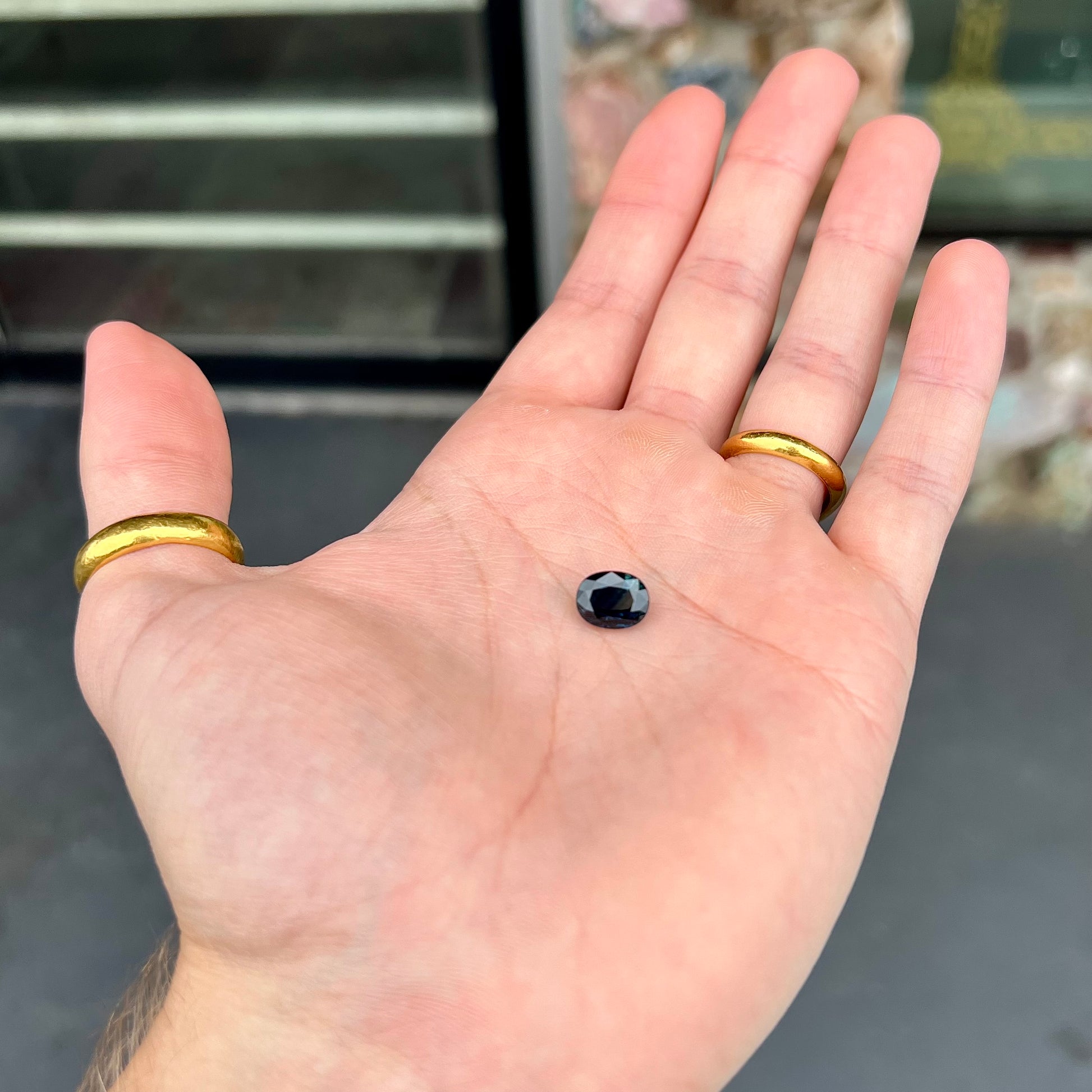 A loose faceted oval cut natural sapphire.  The stone is blue-green color.