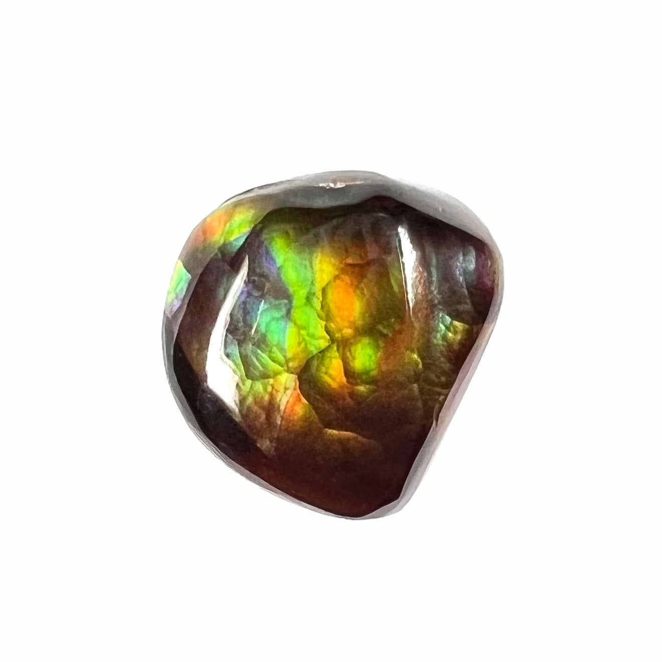 A freeform cabochon cut Mexican fire agate stone.  The stone has a bright purple flash with green, yellow, and orange.