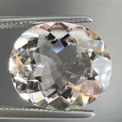 A loose, faceted oval cut pink morganite gemstone.