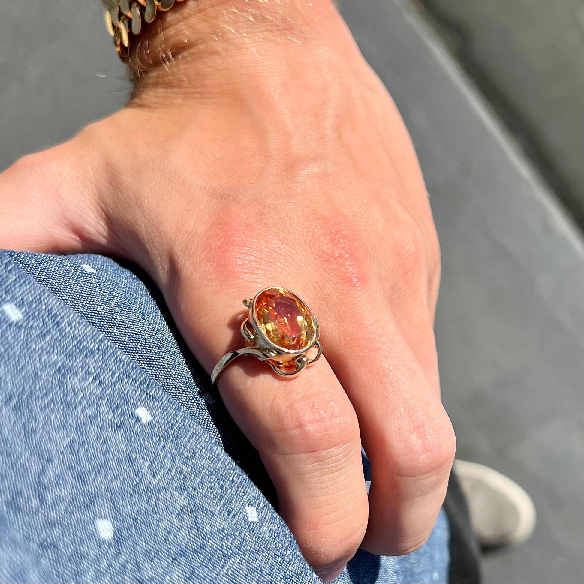 A ladies' yellow gold solitaire ring set with an 8.00 carat oval cut orange hessonite garnet.