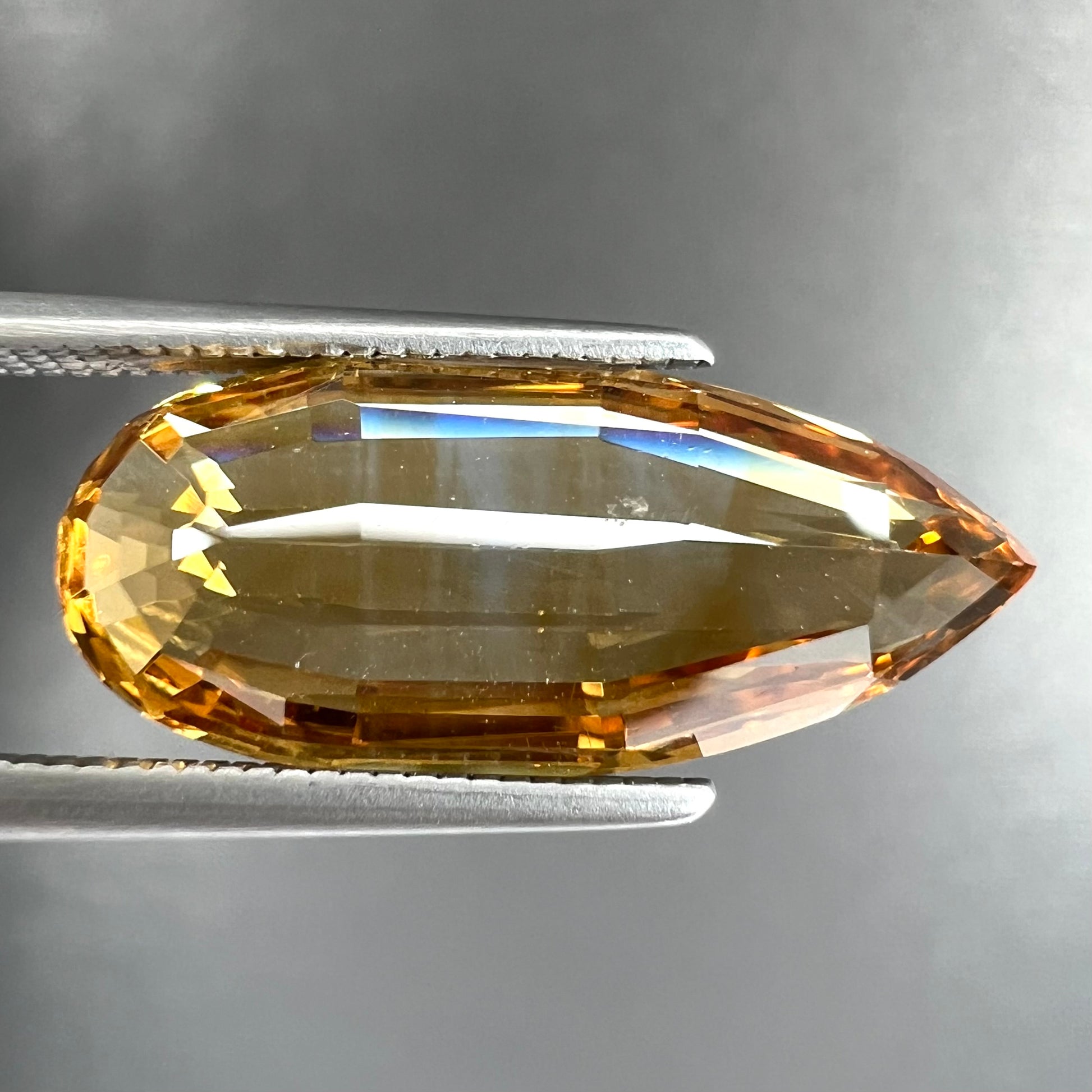 A loose, faceted briolette cut citrine gemstone.