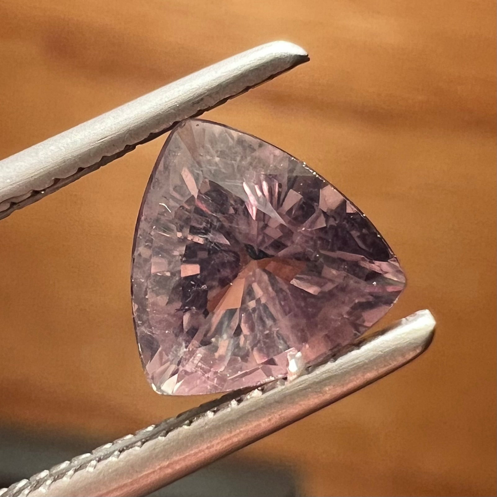 A natural, 1.10 carat, trillion cut alexandrite gemstone.  The stone changes colors from dark olive green to faint purplish green.