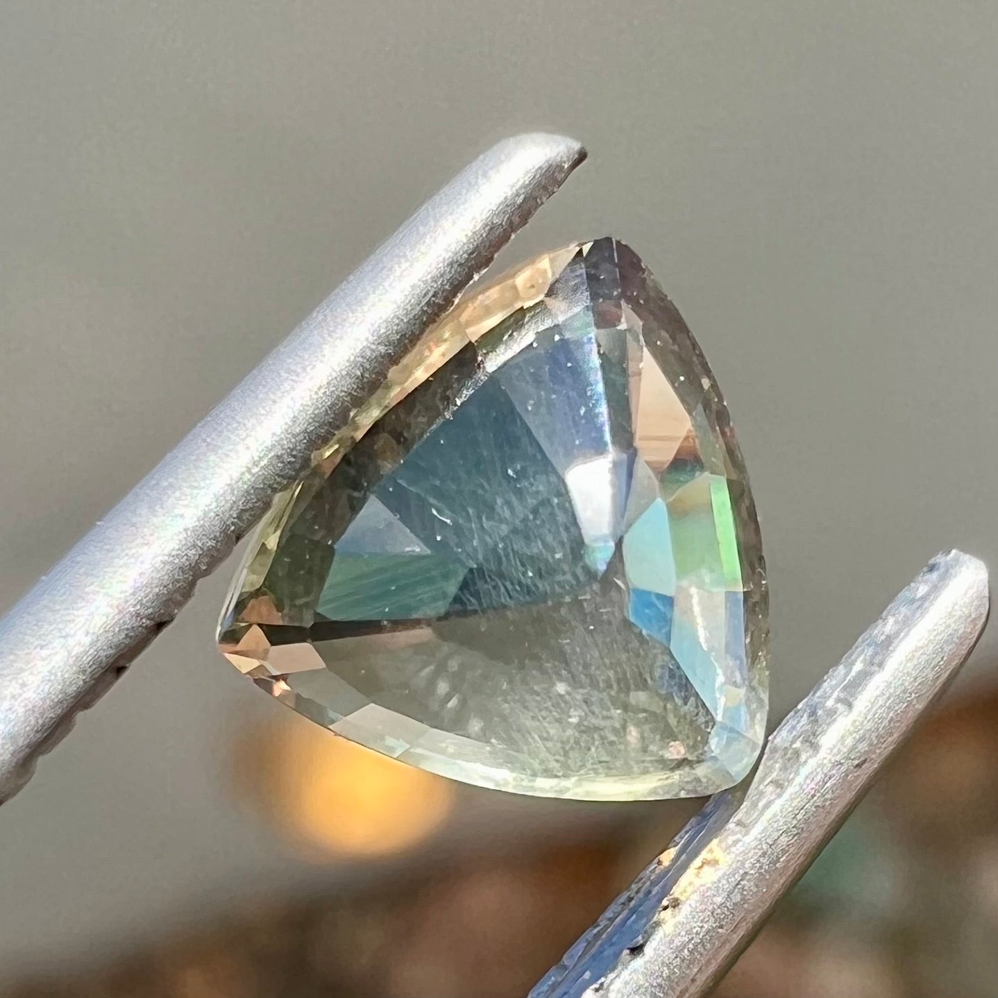 A natural, 1.10 carat, trillion cut alexandrite gemstone.  The stone changes colors from dark olive green to faint purplish green.