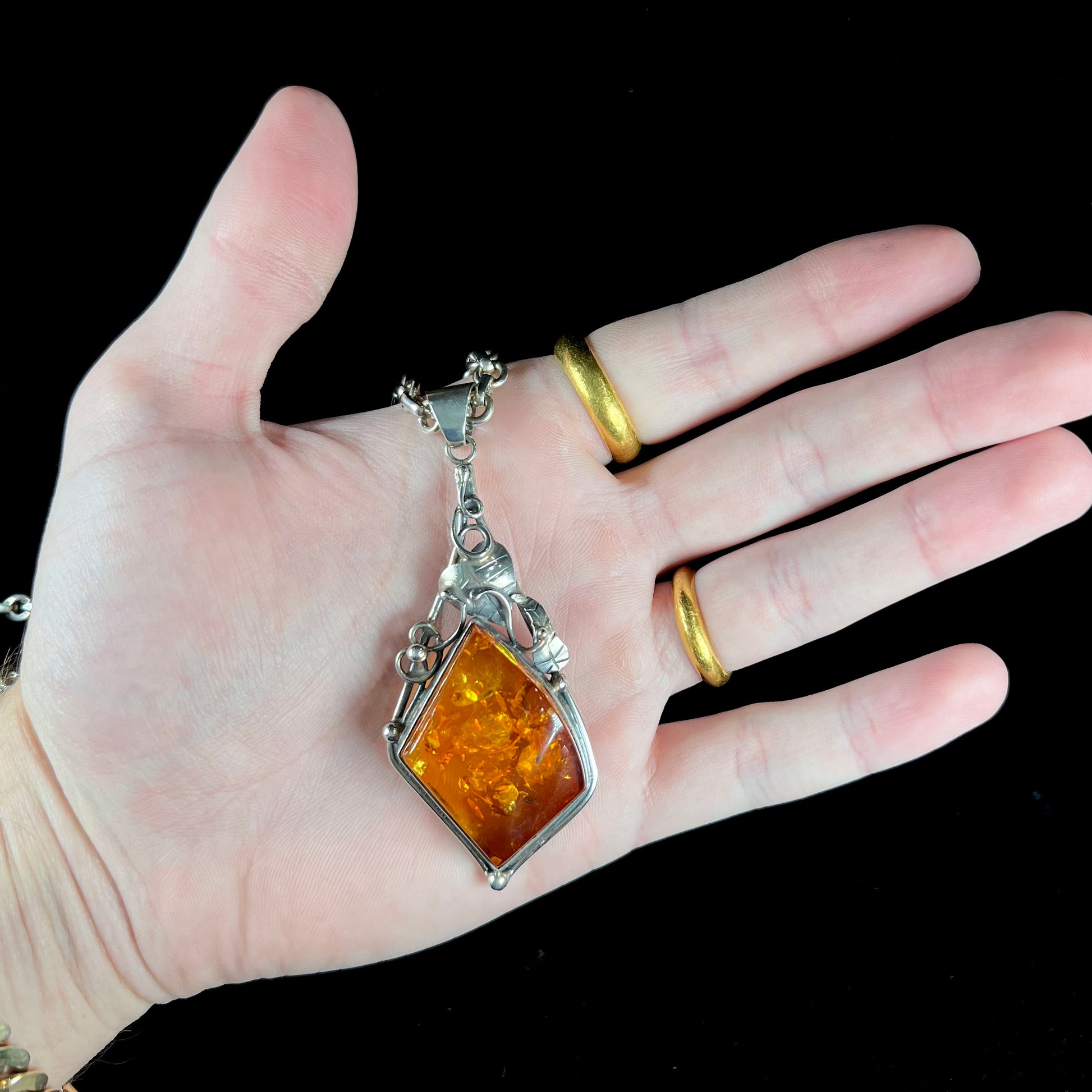 Unisex silver pendant set with a sun-spangled Mexican amber stone, featuring silver leaf design accents.