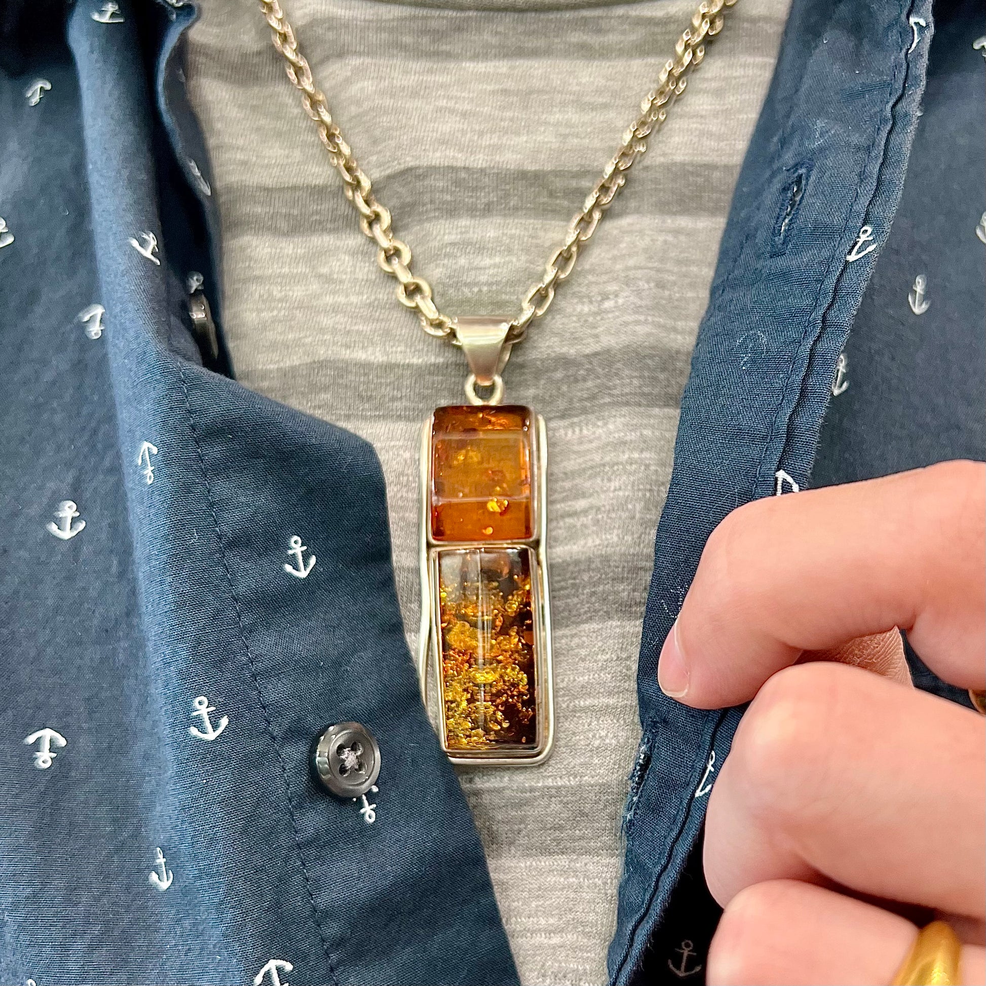 A men's sterling silver pendant set with two rectangle shaped natural amber cabochons.