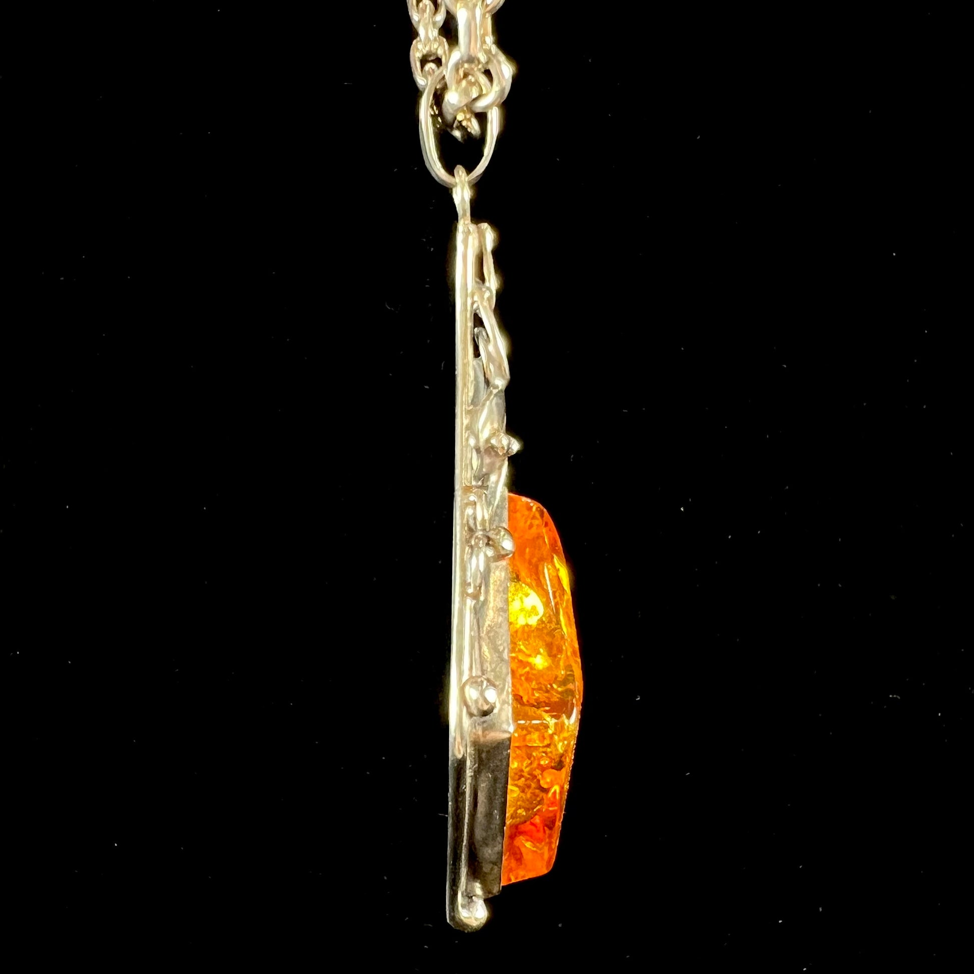 Unisex silver pendant set with a sun-spangled Mexican amber stone, featuring silver leaf design accents.