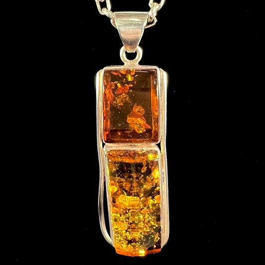 A sterling silver pendant set with two rectangle shaped natural amber cabochons.