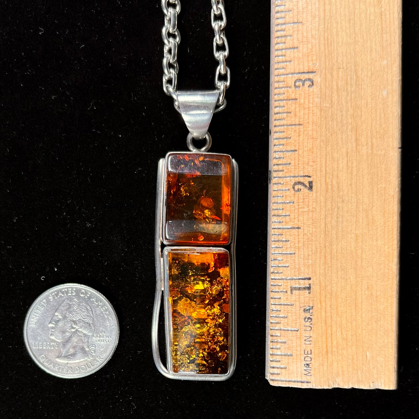A sterling silver pendant set with two rectangle shaped natural amber cabochons.