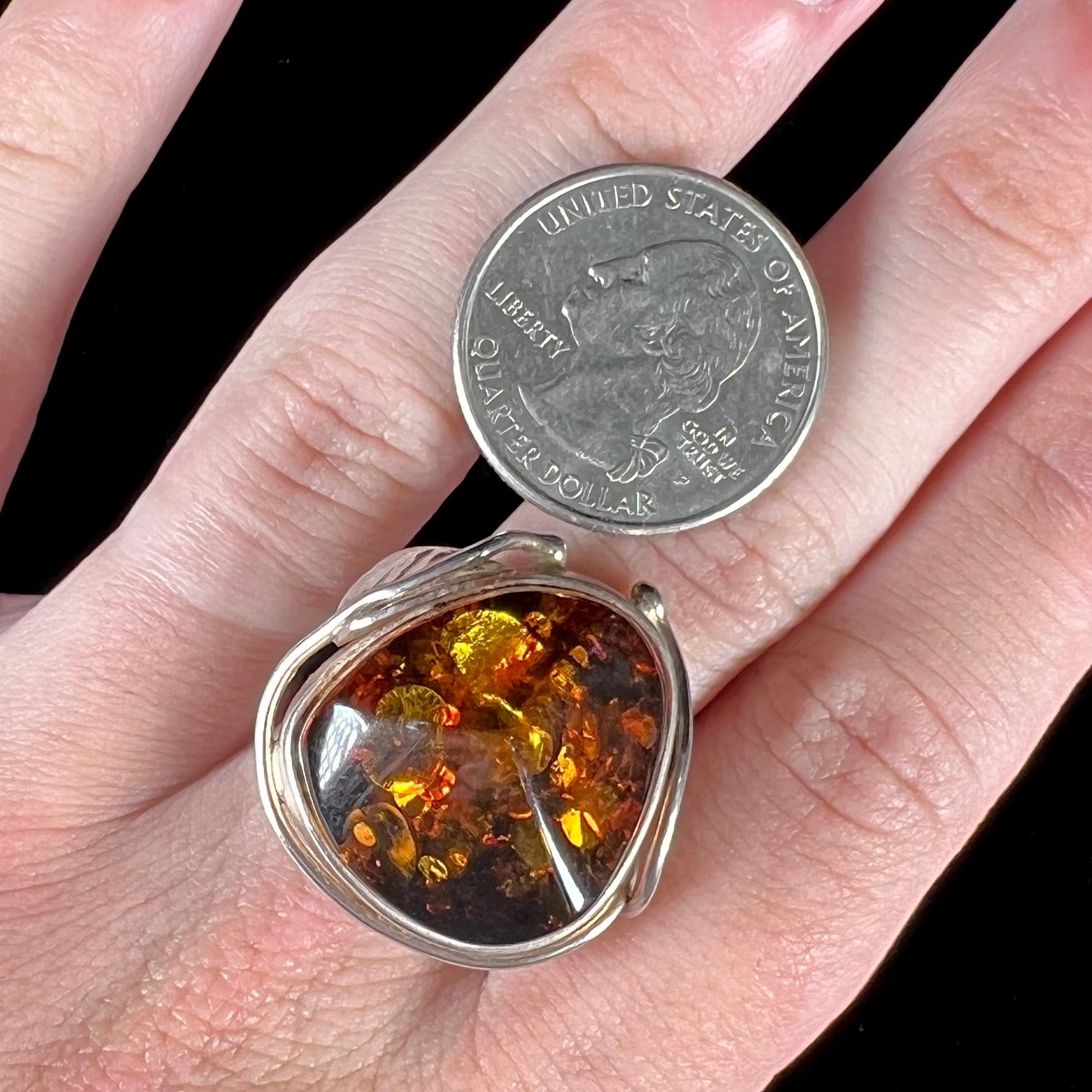 Unisex sterling silver ring set with a large sun-spangled Baltic amber gemstone.