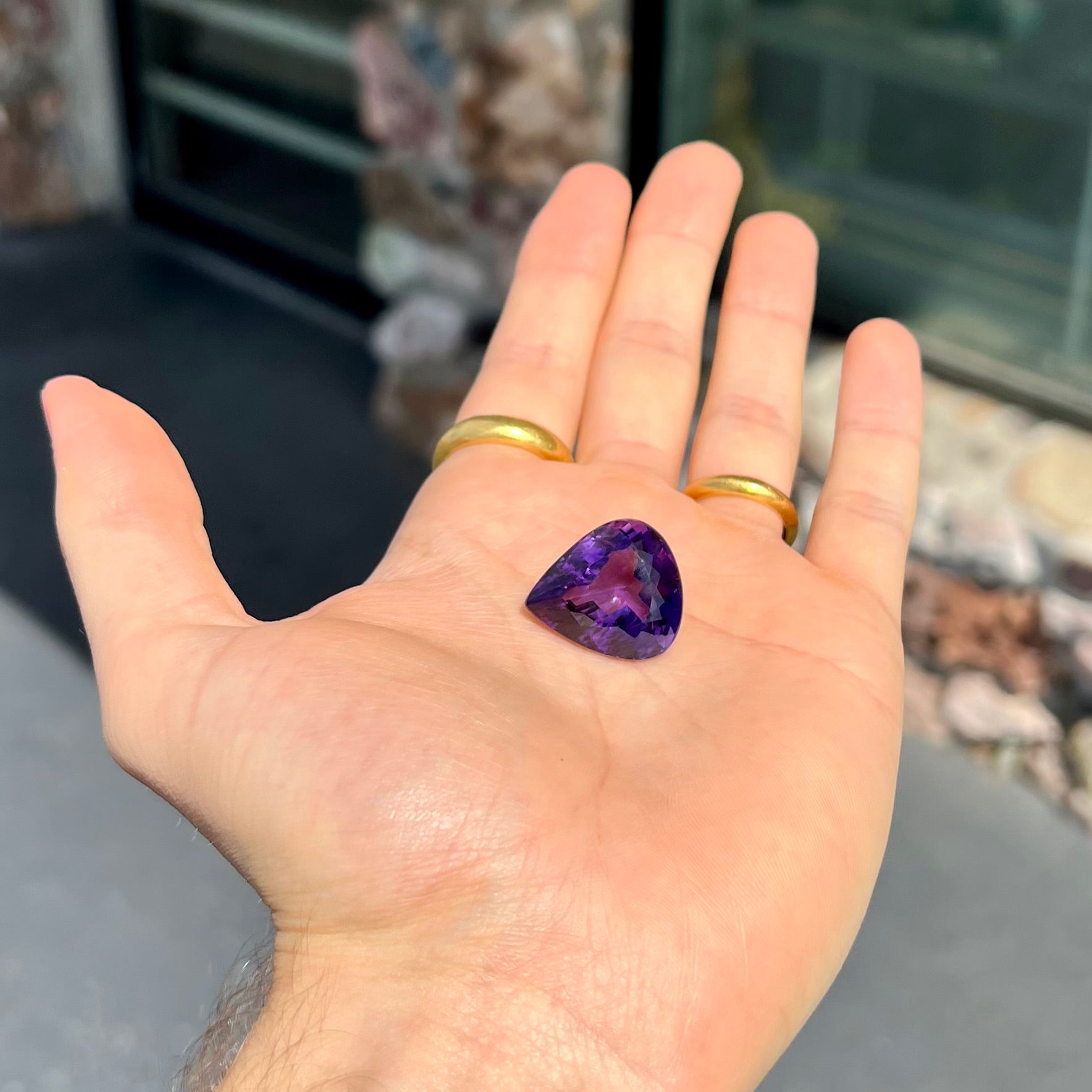 A large, pear shaped amethyst gemstone.  The stone is a dark purple color.