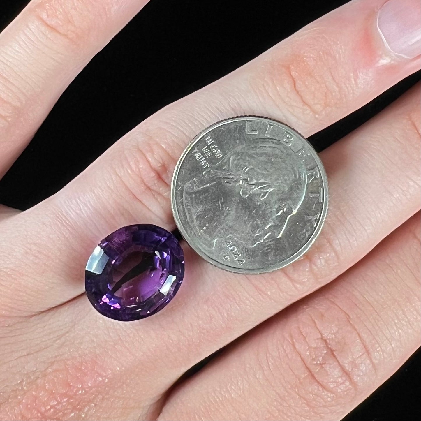 A loose, modified oval cut purple amethyst gemstone.