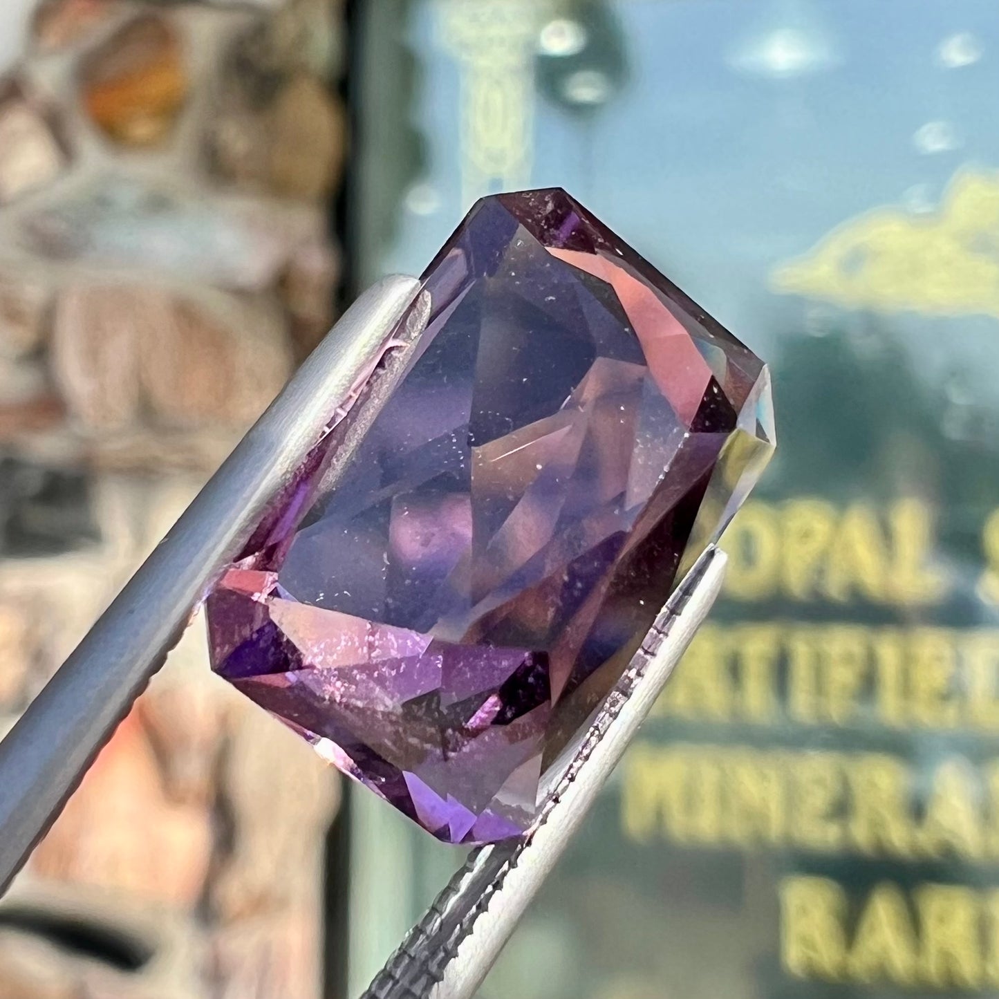 A loose, modified radiant cut amethyst stone.