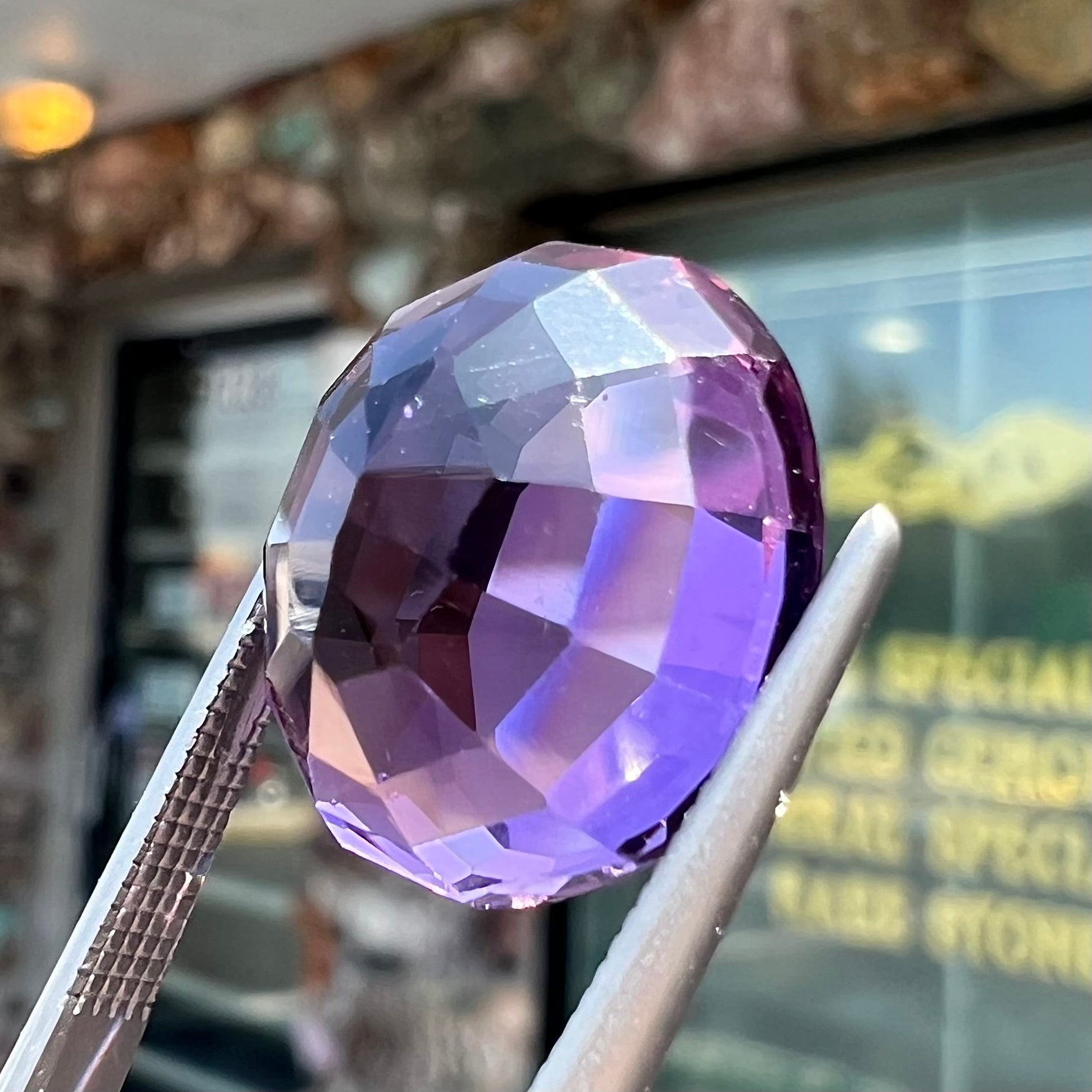 A loose, modified oval cut purple amethyst gemstone.