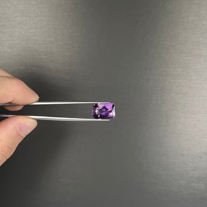 A loose, modified radiant cut amethyst stone.