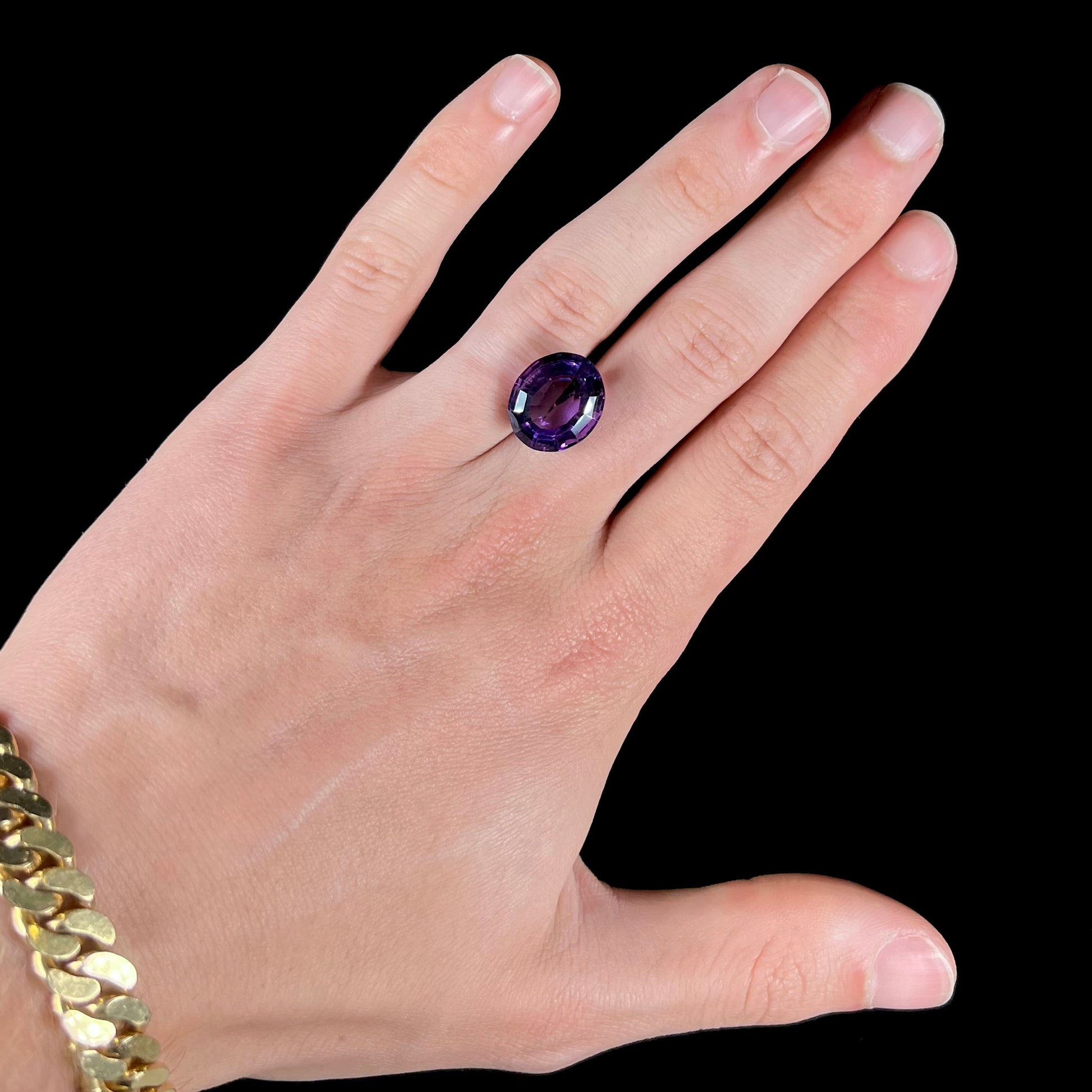 A loose, modified oval cut purple amethyst gemstone.