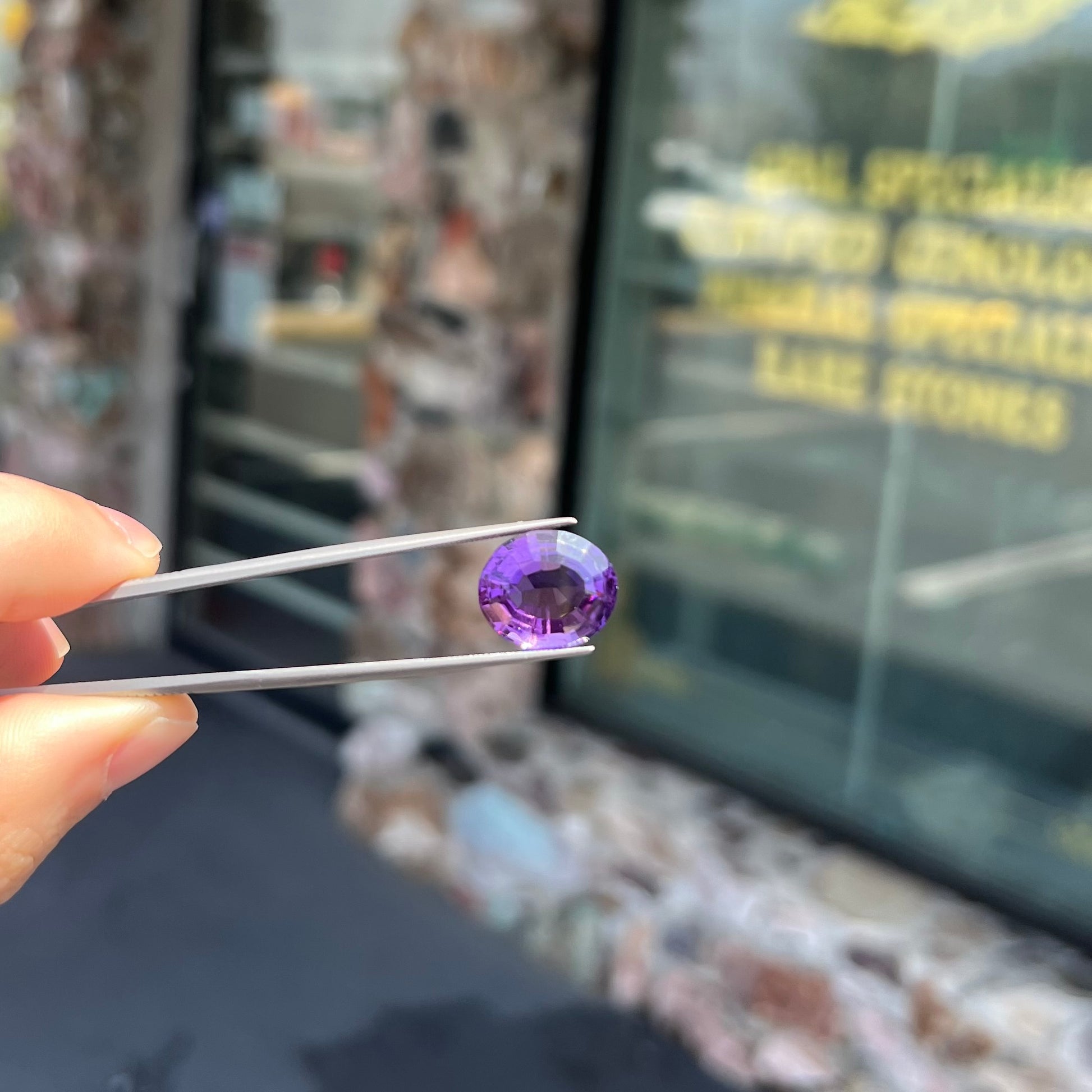A loose, modified oval cut purple amethyst gemstone.