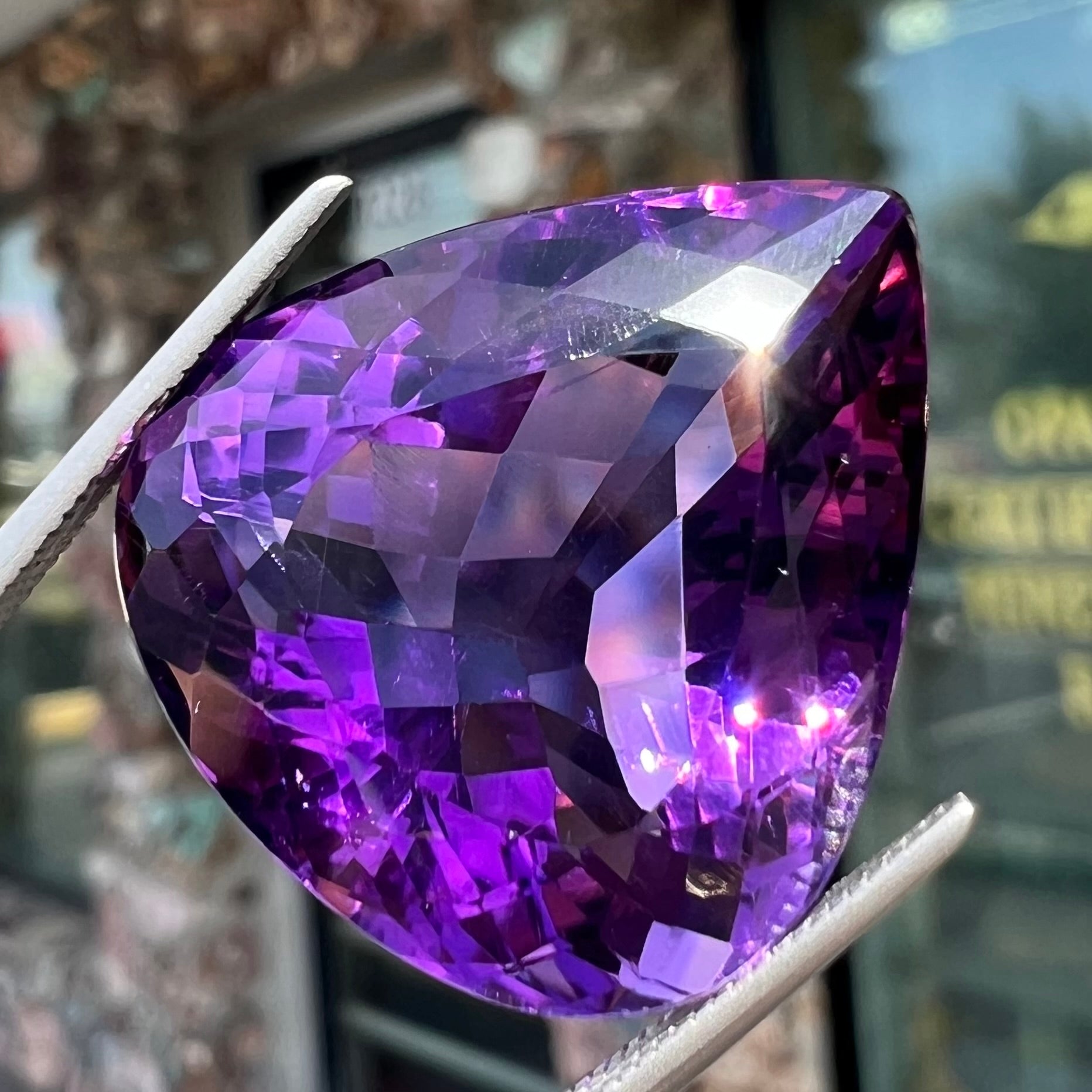 A large, pear shaped amethyst gemstone.  The stone is a dark purple color.