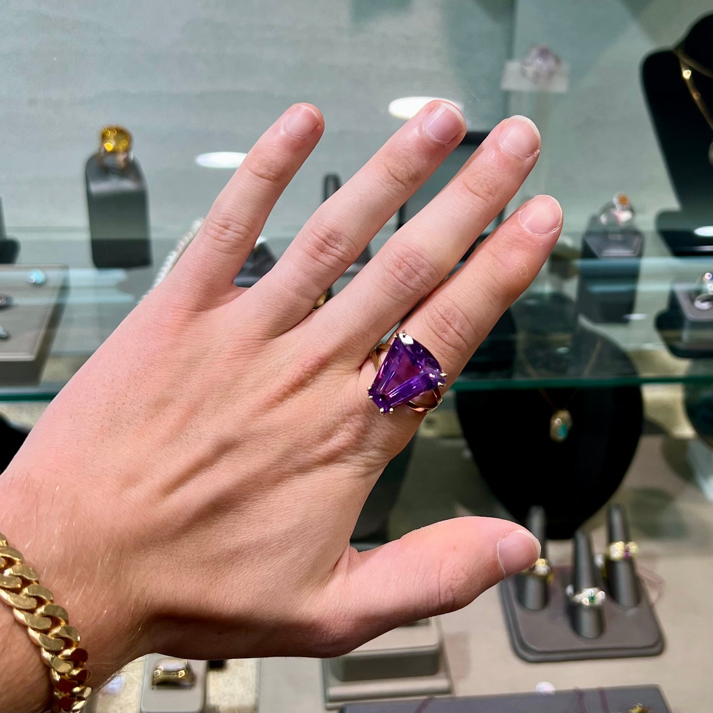 A ladies' yellow gold cocktail ring set with a shield cut purple amethyst gemstone.