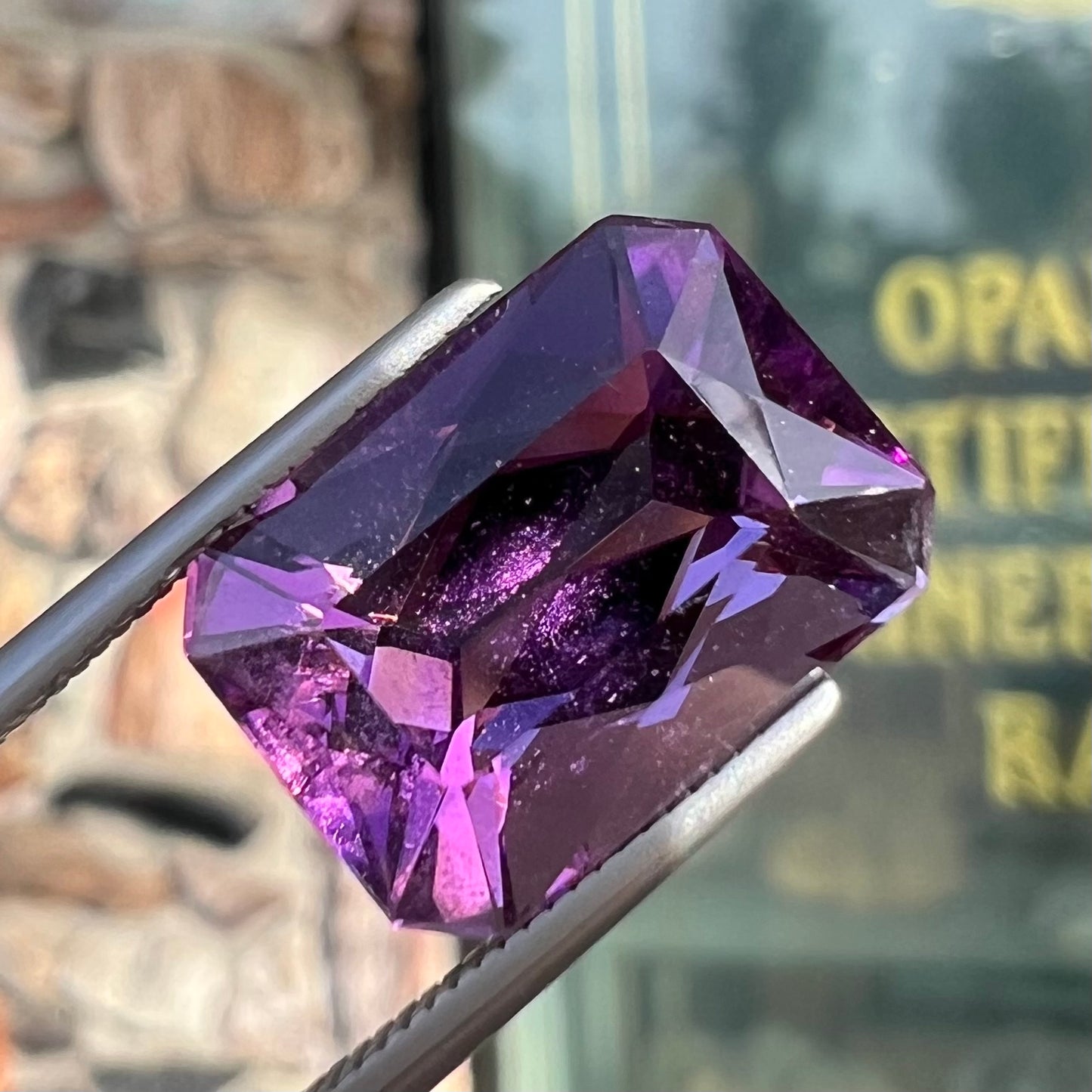 A loose, modified radiant cut amethyst stone.