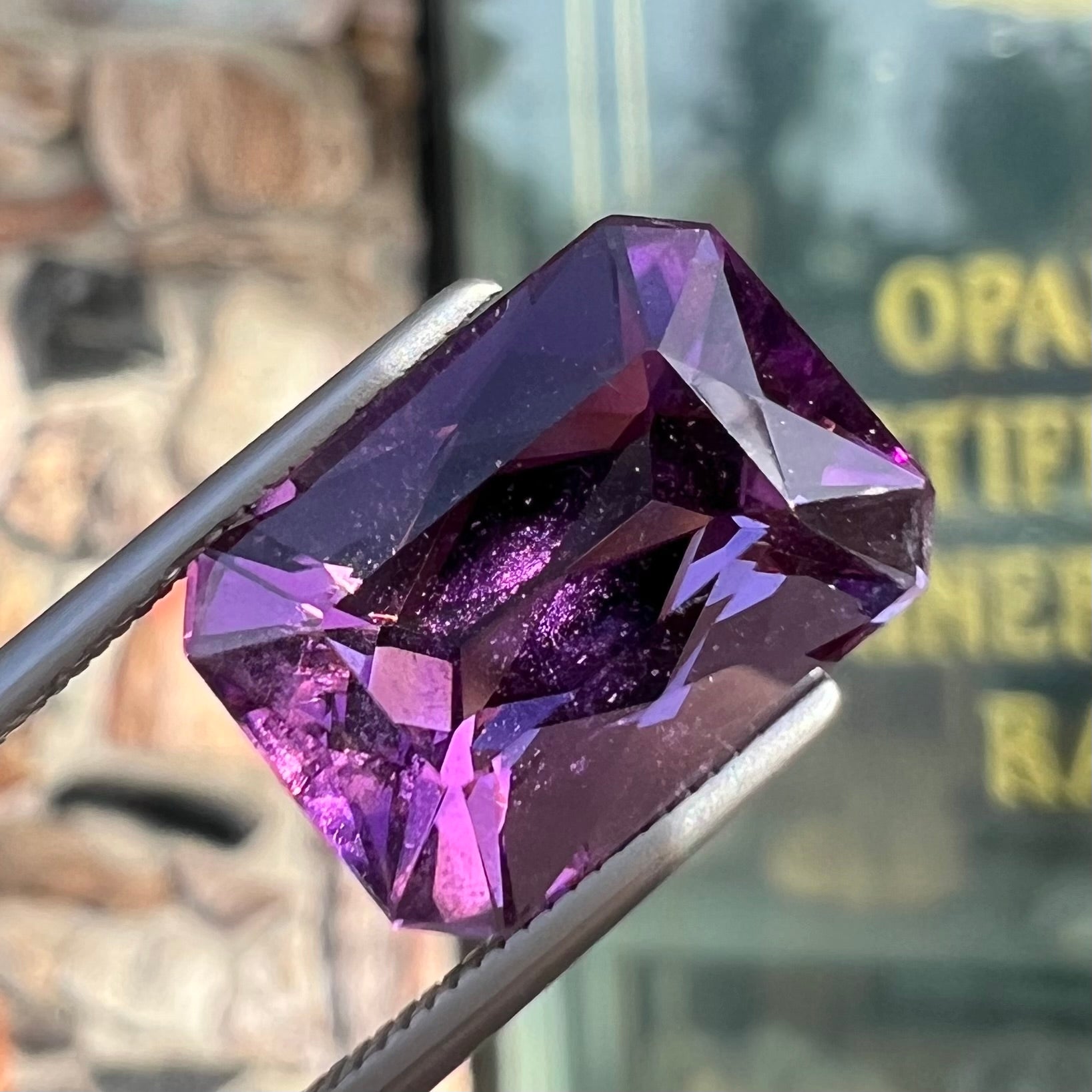 A loose, modified radiant cut amethyst stone.