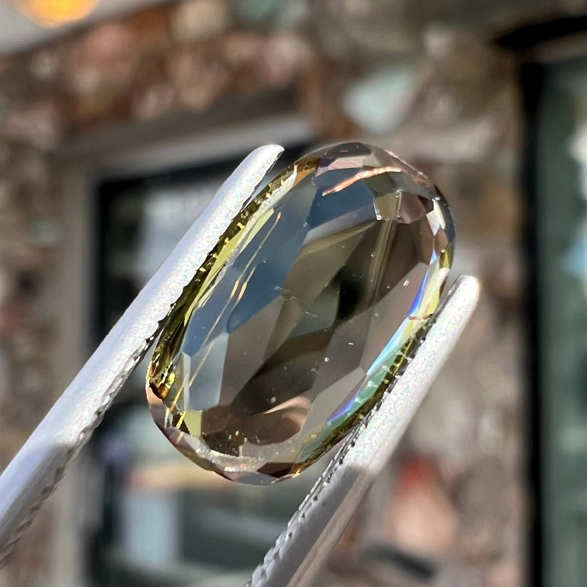 A modified oval cut andalusite gemstone.  The stone has eye-visible rutile inclusions.