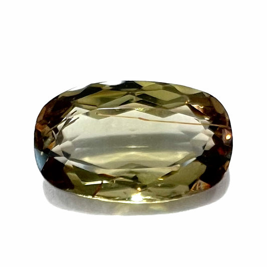 A modified oval cut andalusite gemstone.  The stone has eye-visible rutile inclusions.