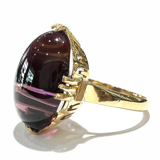 A ladies' 18 karat yellow gold oval cabochon cut amethyst ring.  The ring is 1920's style.