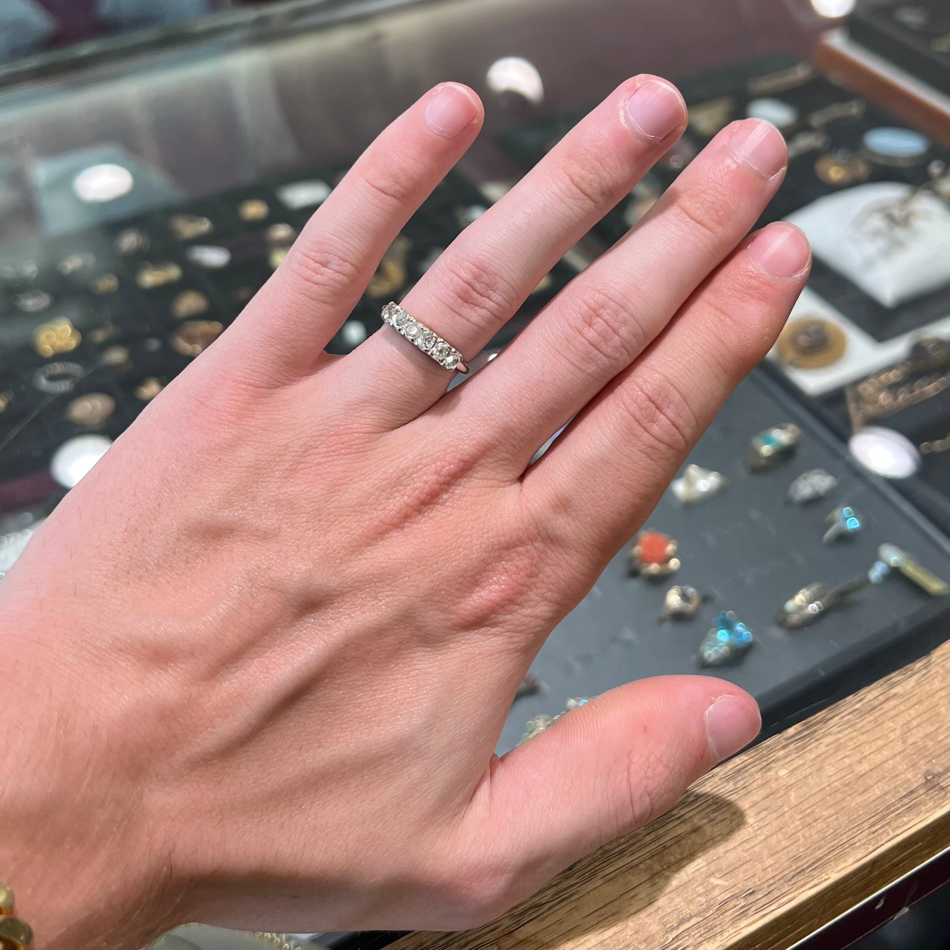 An antique white gold diamond wedding band set with six old mine cut natural diamonds.