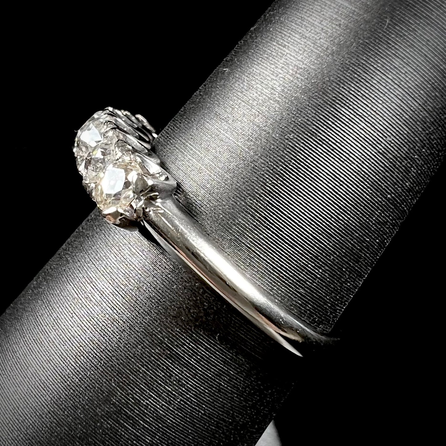 An antique white gold diamond wedding band set with six old mine cut natural diamonds.