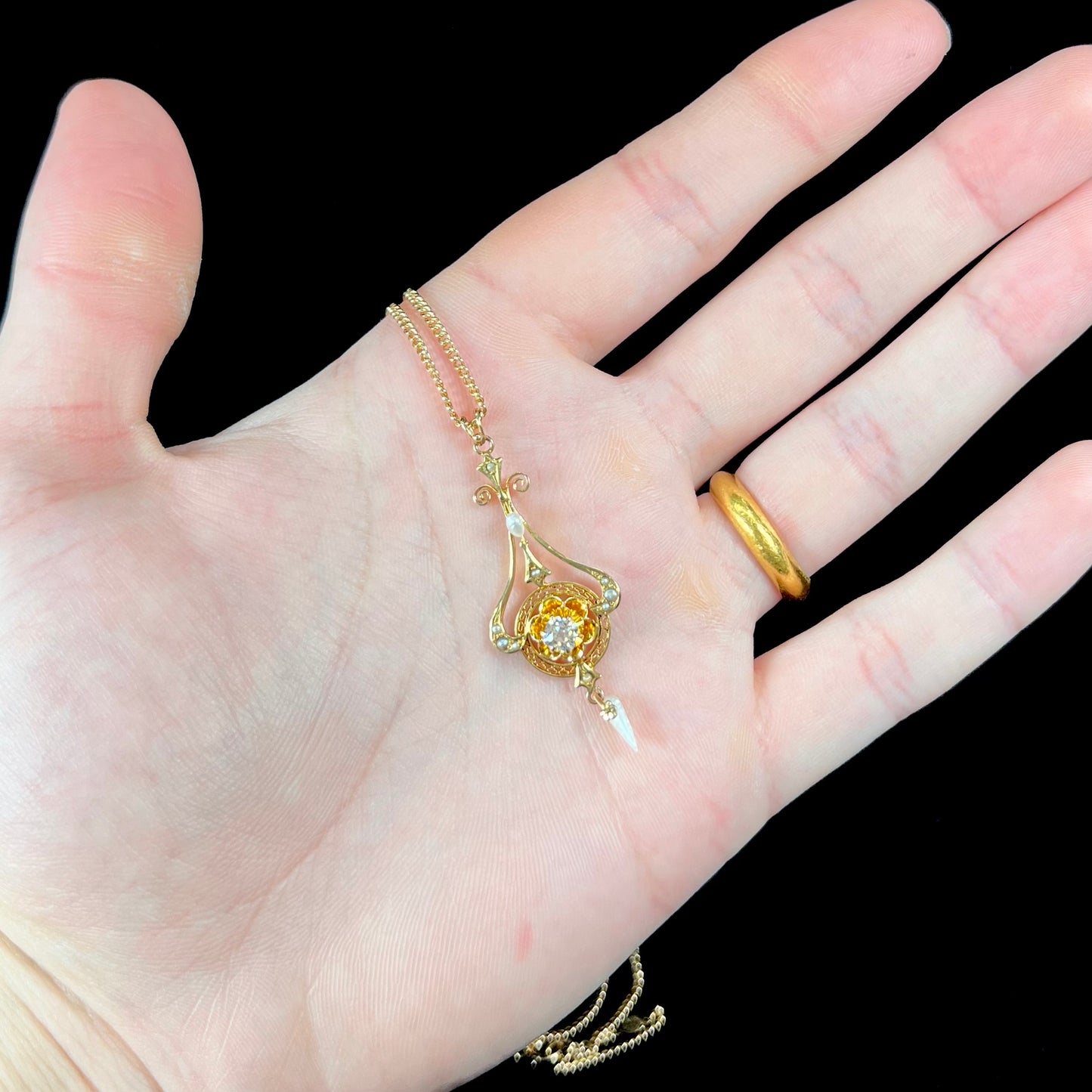 A ladies' Edwardian style gold necklace set with pearls and an old mine cut diamond.  The chain is marked "1916".