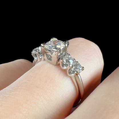 A ladies' 1800's antique white gold diamond ring.  The center stone is an Early American Cut diamond, and the accent stones are Old Mine Cut diamonds.