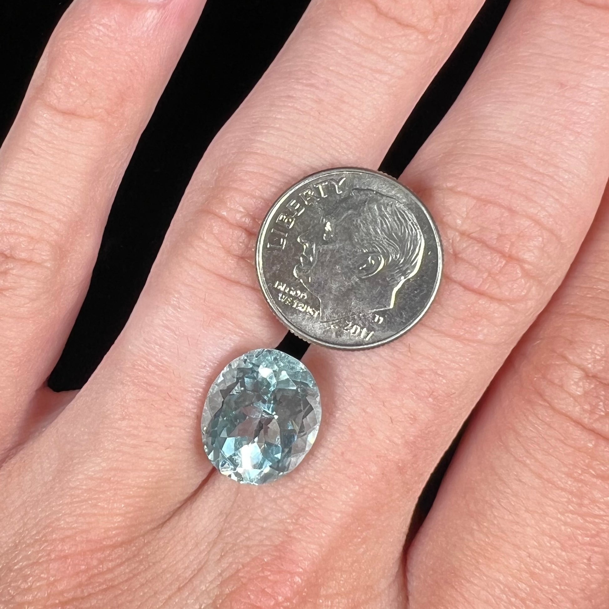 A loose, faceted oval cut aquamarine gemstone from Brazil.  The stone is greenish blue color.
