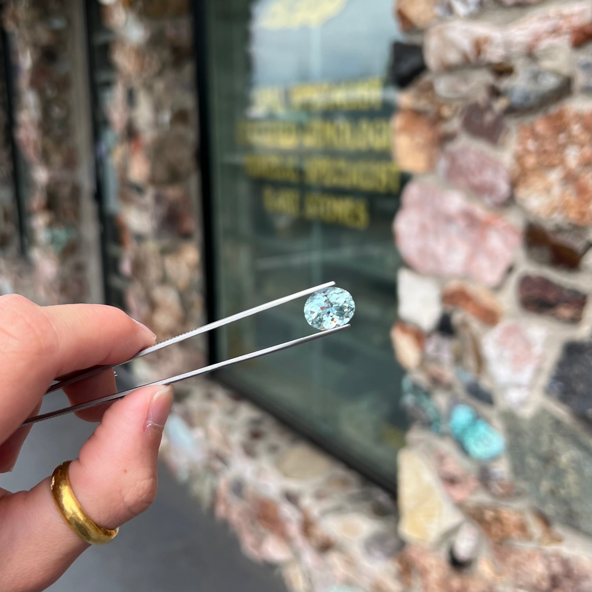 A loose, faceted oval cut aquamarine gemstone from Brazil.  The stone is greenish blue color.