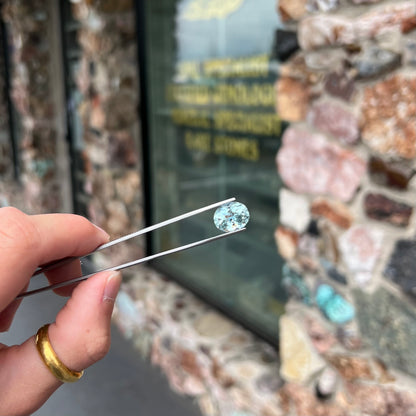 A loose, faceted oval cut aquamarine gemstone from Brazil.  The stone is greenish blue color.