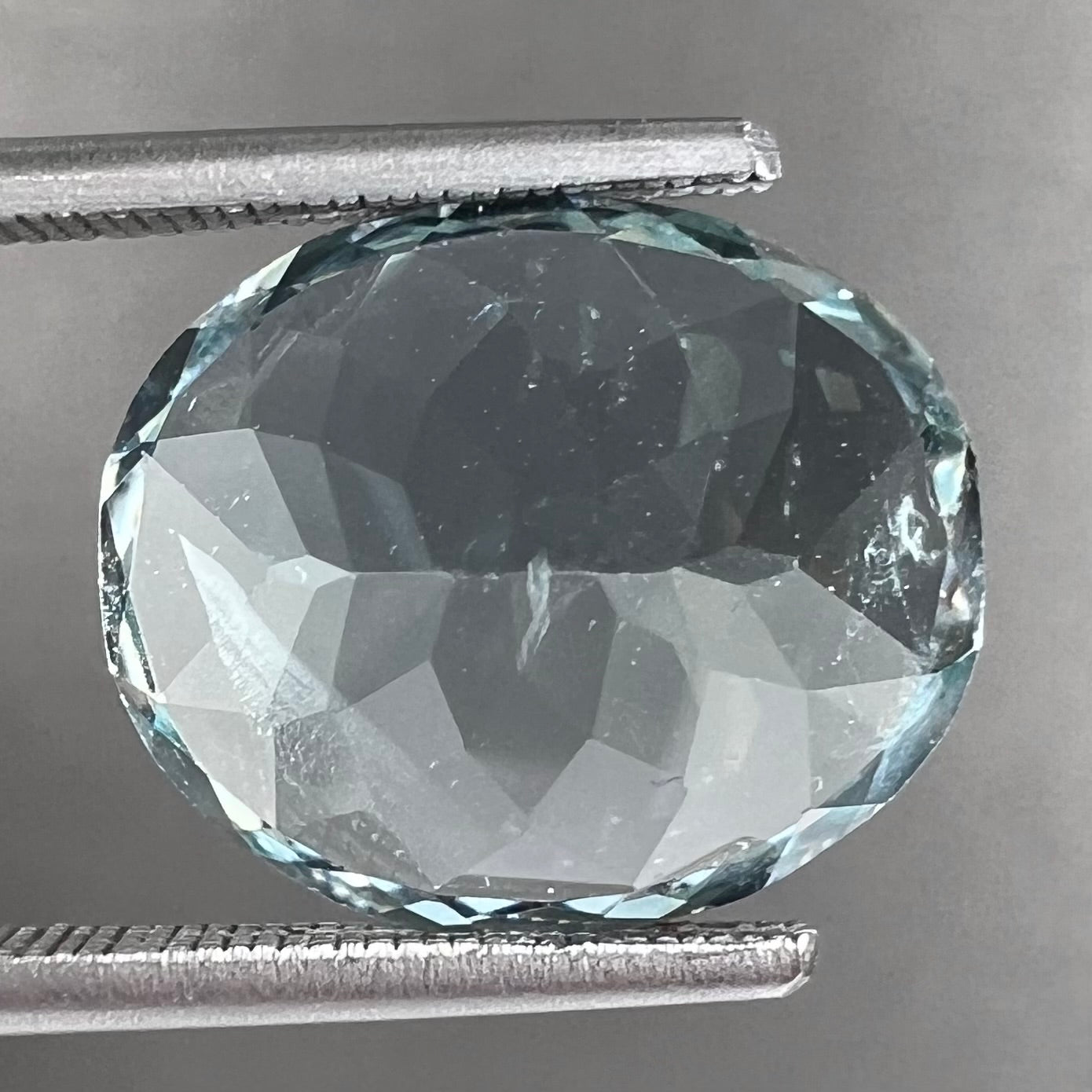 A loose, faceted oval cut aquamarine gemstone from Brazil.  The stone is greenish blue color.