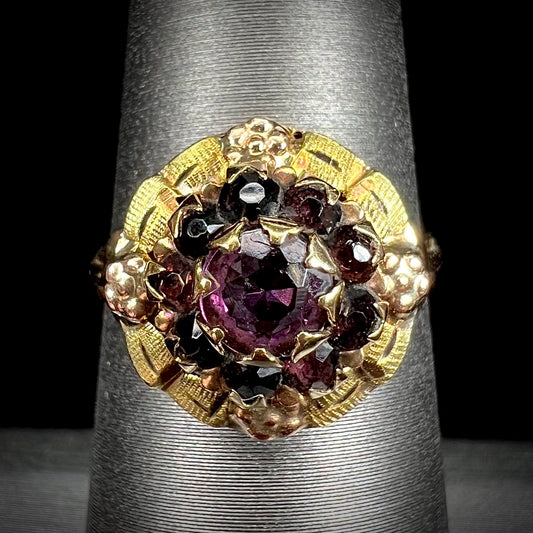 A ladies' Art Nouveau style rhodolite garnet halo ring.  Rose gold flowers accent the piece.