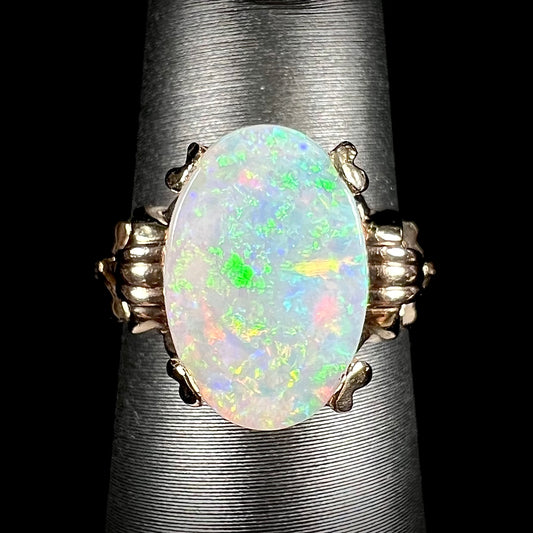 A ladies' Art Deco style natural opal solitaire ring in yellow gold.  The opal is oval cut.