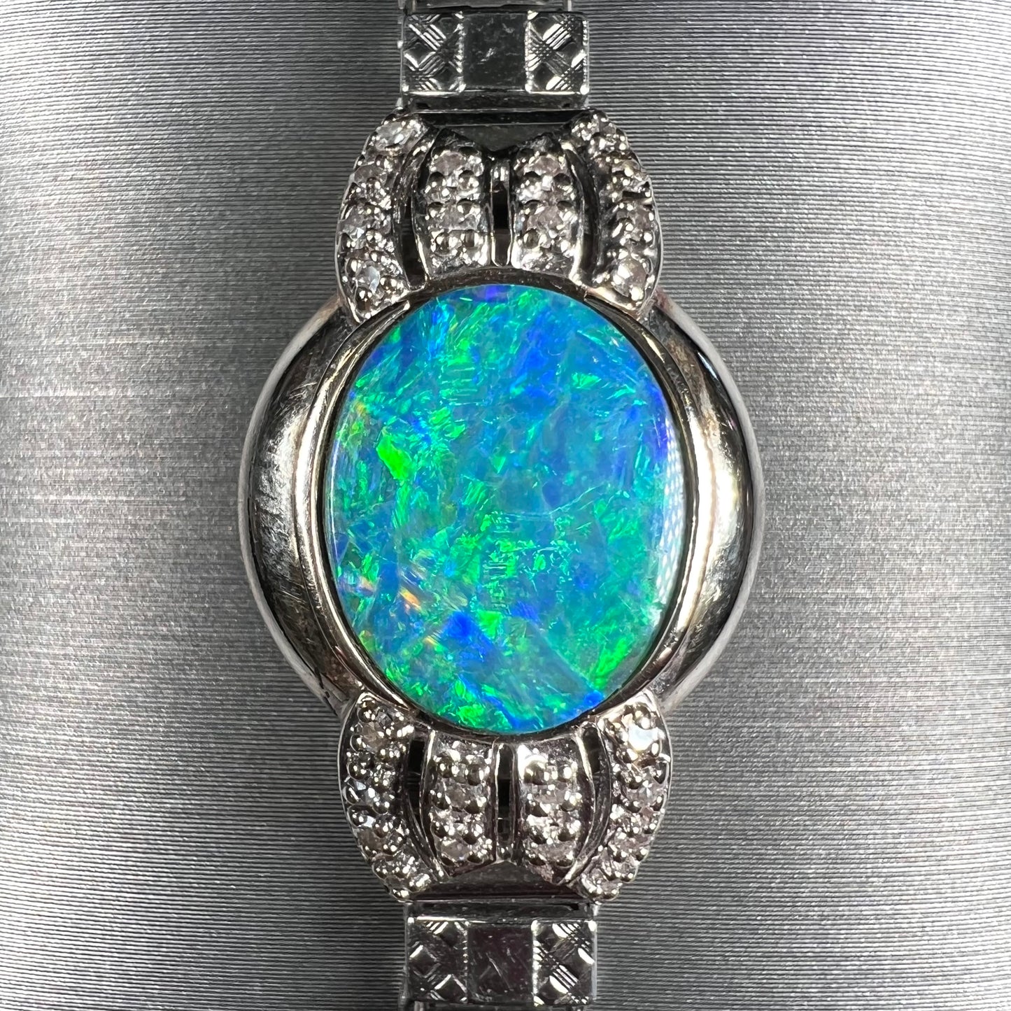 A ladies' art deco style white gold and stainless steel bracelet set with a natural black opal doublet and diamonds.