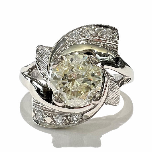 A vintage, Art Nouveau style diamond engagment ring.  The ring is white gold with a yellowish, M colored, 1.24 carat diamond.