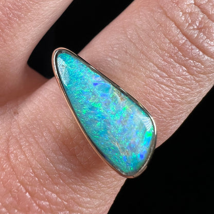 A ladies yellow gold solitaire ring bezel set with a natural opalized seashell from Coober Pedy, Australia.