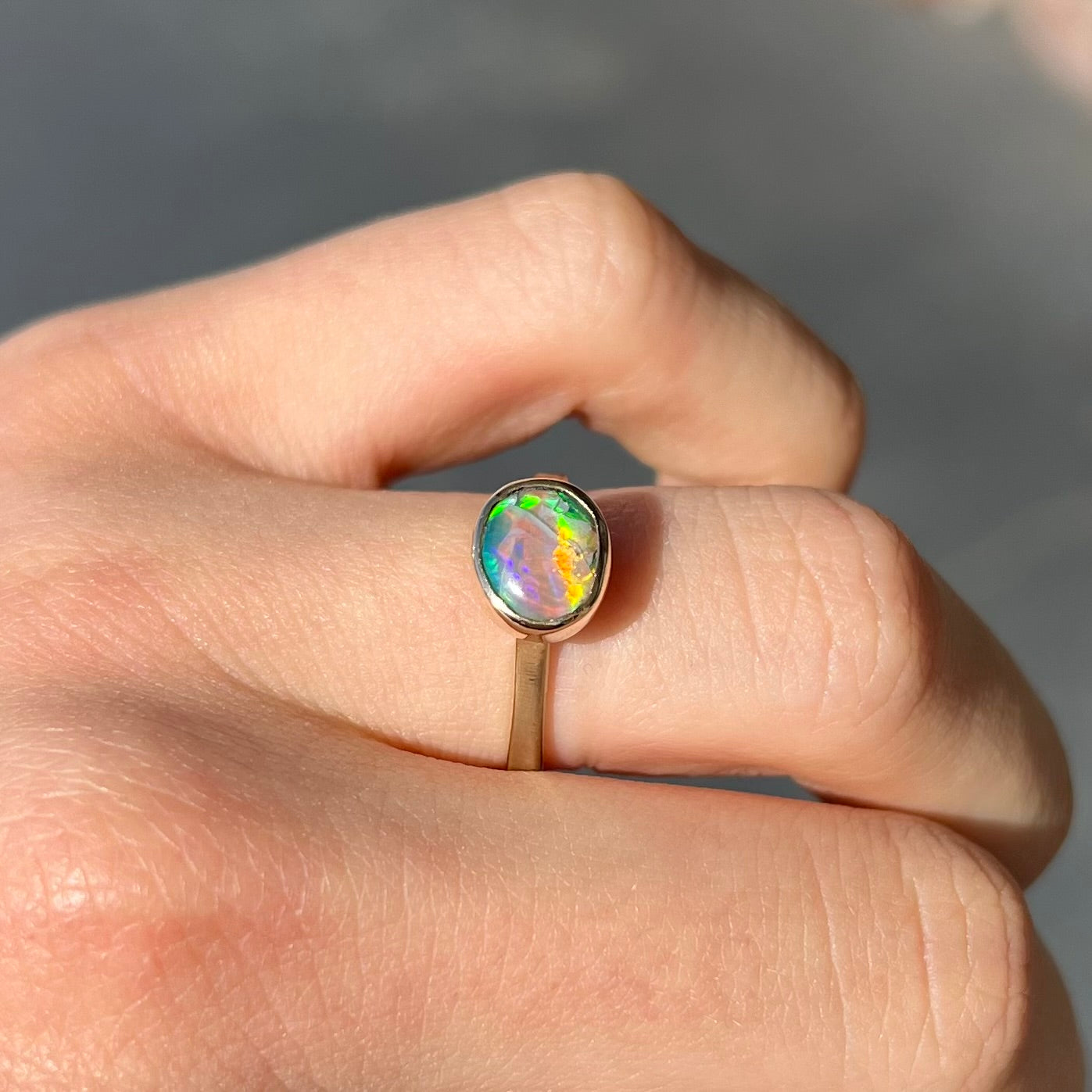 A yellow gold solitaire ring set with a natural Australian cat's eye opal stone.