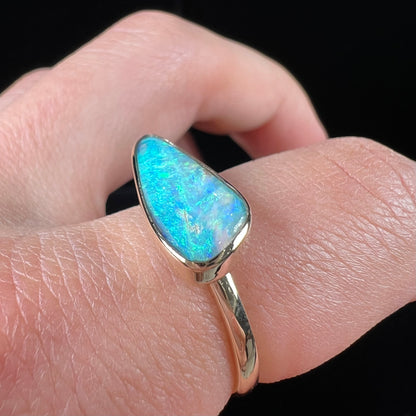A ladies yellow gold solitaire ring bezel set with a natural opalized seashell from Coober Pedy, Australia.