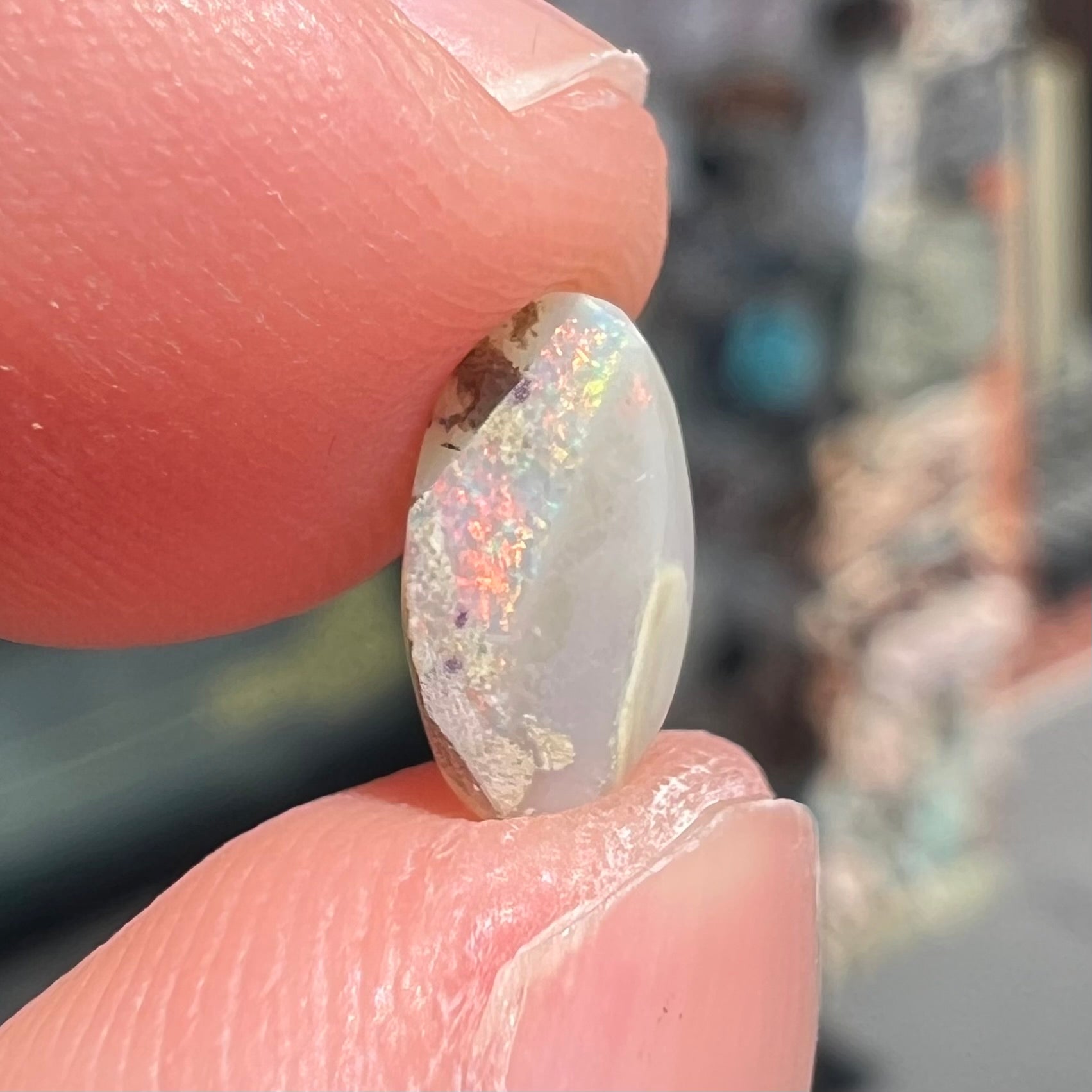 A loose, light opal from Lightning Ridge, Australia.  The opal shines a rainbow of colors.