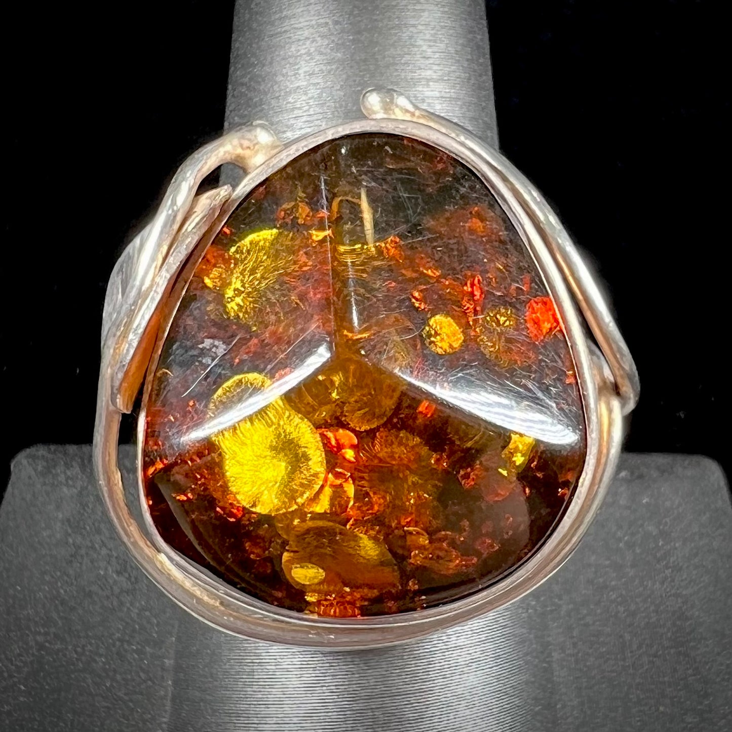 Unisex sterling silver ring set with a large sun-spangled Baltic amber gemstone.