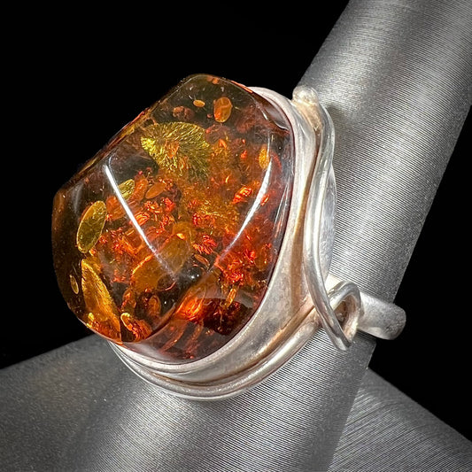 Unisex sterling silver ring set with a sun-spangled Baltic amber gemstone.