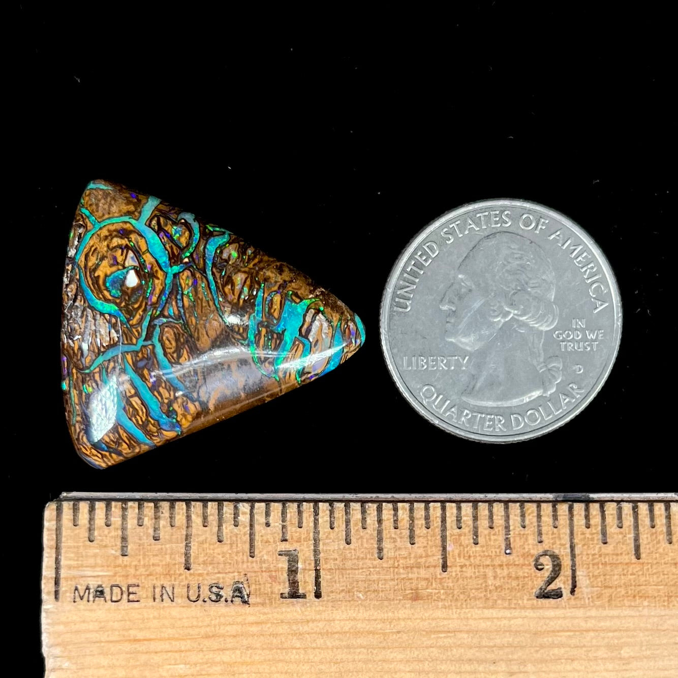 A triangle shaped Koroit boulder opal.  The stone has blue veins of opal running through it.