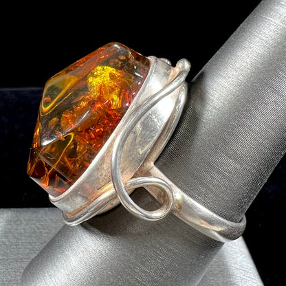 Unisex sterling silver ring set with a large sun-spangled Baltic amber gemstone.