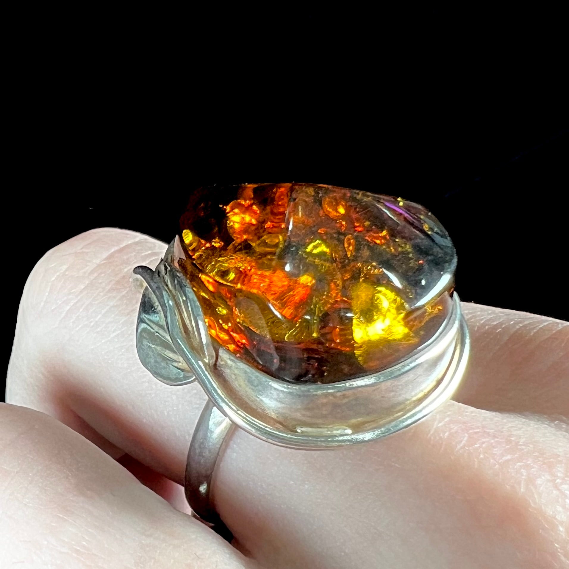 Unisex sterling silver ring set with a large sun-spangled Baltic amber gemstone.