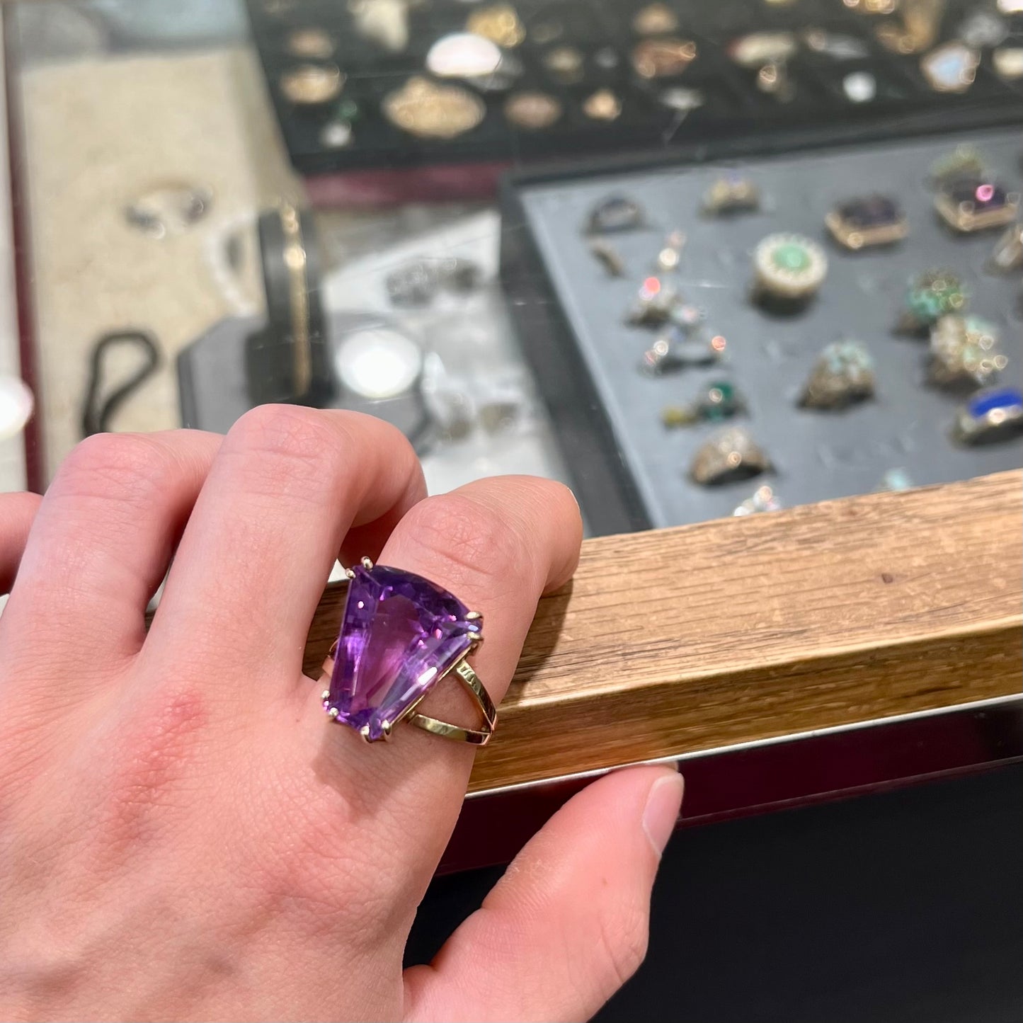 A ladies' yellow gold cocktail ring set with a shield cut purple amethyst gemstone.