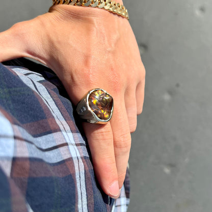 A men's heavy yellow gold ring set with a Mexican fire agate stone and three round brilliant cut diamond accents.